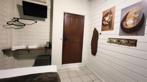 a room with a door and a television in a room at Recanto da Dona Luiza - Pousada in Florianópolis