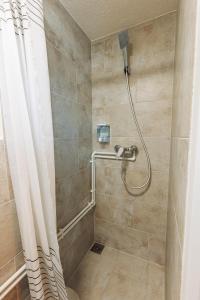 a bathroom with a shower with a shower curtain at Cabana Vitus Panzió in Harghita-Băi