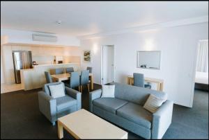 a living room with a couch and chairs and a table at River's Edge Premium Retreat in Ballina