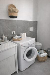 a bathroom with a washing machine and a toilet at La riva in Noto Marina