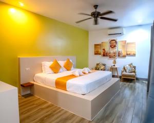 a bedroom with a bed with yellow and green walls at Bali Villas Panglao Bohol in Panglao Island