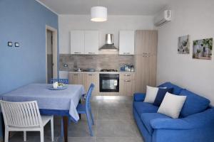 a living room with a table and a blue couch at La riva in Noto Marina