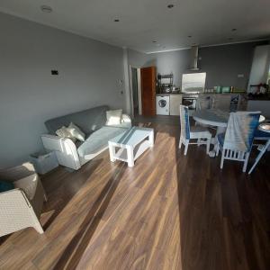 a living room with a couch and a table and chairs at Sea View Apartment in Cobh