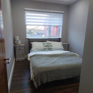 a small bedroom with a bed with a window at Sea View Apartment in Cobh