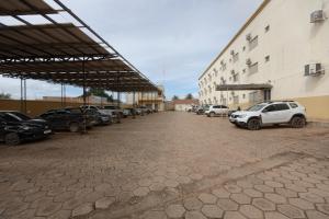 a parking lot with cars parked next to a building at Aldeias Palace Hotel in Tucuma