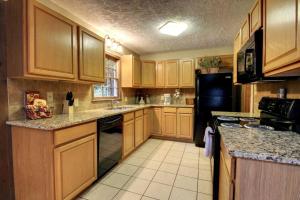 a kitchen with wooden cabinets and a black refrigerator at Alpine Getaway 62 in Helen +10 photos