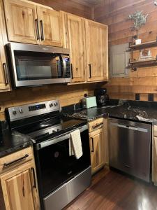 a kitchen with stainless steel appliances and wooden cabinets at Bavarian Hideaway 46 in Sautee Nacoochee