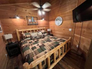 a bedroom with a bed in a room with wooden walls at Bavarian Hideaway 25 in Helen