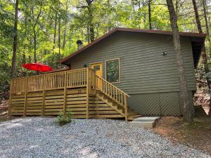 a house with a wooden deck with a red umbrella at Bavarian Hideaway 25 in Helen
