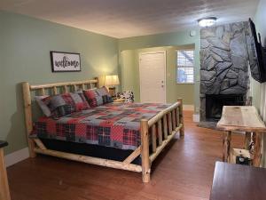 a bedroom with a wooden bed and a stone fireplace at Bavarian Brook Unit 7 in Helen