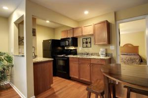 a kitchen with wooden cabinets and a table and a kitchen with a dining room at Bavarian Brook Condo 11 in Helen