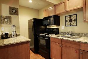 a kitchen with a black refrigerator and a sink at Bavarian Brook Condo 11 in Helen
