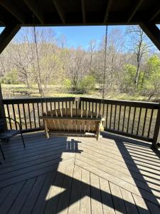 a swing on a porch with a view of a river at Rivers Edge 703c in Helen
