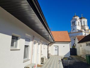 a walkway between two buildings with a clock tower at Smeštaj kod Lazarice Šid in Šid