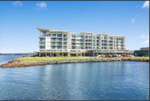 a large building sitting on top of a body of water at Water Front Retreat Ballina in Ballina