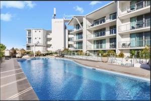 a swimming pool in front of a building at Water Front Retreat Ballina in Ballina
