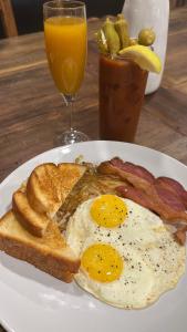a plate of breakfast food with eggs bacon and toast at Hotel Henry Cafe and Bar in Blanco