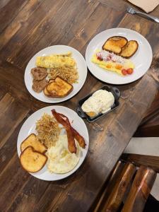 four plates of breakfast food on a wooden table at Hotel Henry Cafe and Bar in Blanco +24 photos