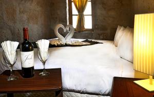 uma cama com uma garrafa de vinho e dois copos de vinho em Hoteles Riviera Colonial em Arequipa