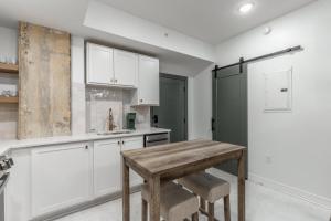 a kitchen with white cabinets and a wooden table at Park Hotel Studio Suite 303 in Chattanooga