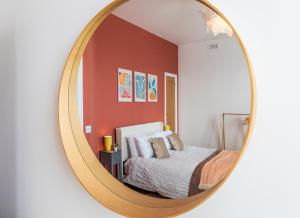 a mirror reflecting a bedroom with a bed at Harbour-View Apartment Facing HMS Warrior in Portsmouth
