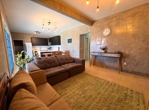 a living room with a brown couch and a kitchen at Casa Cações Beach Marataizes in Marataizes