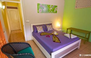 a bedroom with a purple bed and a chair at Le Benitier in Port Mathurin