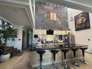 a kitchen with a bar with stools in a room at Residencia con alberca in Las Ánimas