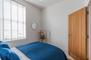 a bedroom with a blue bed and a window at Harbour-View Apartment Facing HMS Warrior in Portsmouth +21 photos