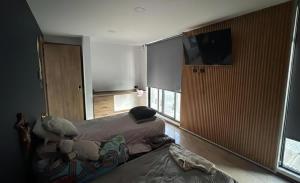 a bedroom with a bed and a flat screen tv at Residencia con alberca in Las Ánimas