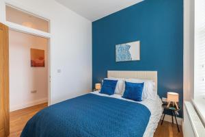 a blue bedroom with a bed with blue sheets at Harbour-View Apartment Facing HMS Warrior in Portsmouth