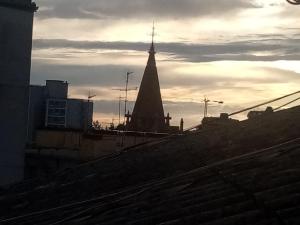 a view of a church steeple from a rooftop at Affitta camere Explora caffè in Trieste +13 photos