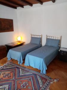a bedroom with two beds and a table with a rug at Affitta camere Explora caffè in Trieste