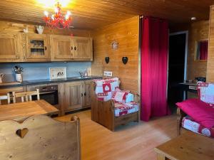 a kitchen with wooden cabinets and a pink curtain at Chalet dans le parc régional du Haut-Jura in Saint-Laurent-en-Grandvaux