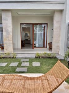 a patio with a hammock in front of a house at Paramulia house in Canggu +1 photo