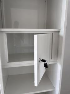 a white cabinet with a glass door with a black handle at Paramulia house in Canggu