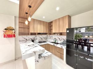 a kitchen with wooden cabinets and a black refrigerator at Paramulia house in Canggu