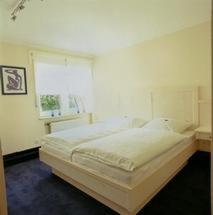 a bedroom with a large white bed with a window at Hotel Veltrup in Laer