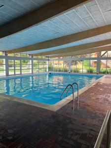 a swimming pool in a building with a large window at Chalet dans le parc régional du Haut-Jura in Saint-Laurent-en-Grandvaux