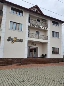 a white building with a hotel sign on it at Hotel Infinit in Târgu Jiu
