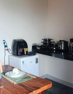 a kitchen with a counter with a stove and a table at Chalé Corina in Pirenópolis