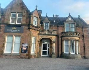 an old brick building with a sign on the door at Crown Hotel & Bar in Inverness