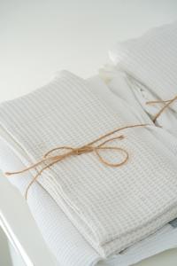 a stack of white towels with a brown bow at Villaggio Campeggio Nettuno di Paestum in Paestum