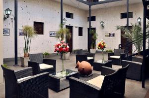 un patio con sillas, mesas y flores en un edificio en Hoteles Riviera Mansion, en Arequipa
