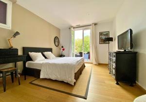 a bedroom with a bed and a piano and a television at G-63 - Appartement de standing en plein coeur d'Hossegor in Soorts-Hossegor +21 photos