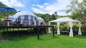 two tents in a yard with a table and chairs at Glamping Claro de Luna in Guatavita