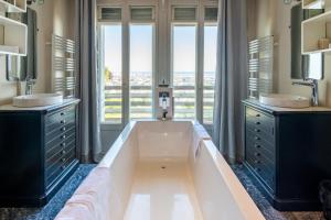 a large bathroom with two sinks and a large tub at Maison Valmer - L'armateur, élégant penthouse classé 4 étoiles in Le Havre +39 photos