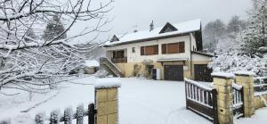 a house covered in snow with a fence at Gîte des sources in Salbert +4 photos