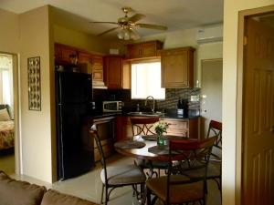 a kitchen with a table and chairs and a black refrigerator at Pedro Villas in Tamuning