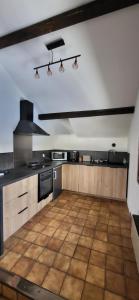 a large kitchen with a wooden floor in a room at Gîte des sources in Salbert